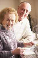 Rentnerpaar steht lachend in der Küche
