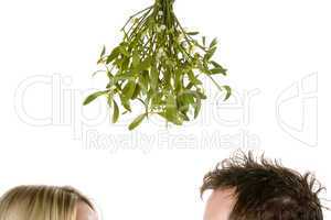 Couple standing under mistletoe