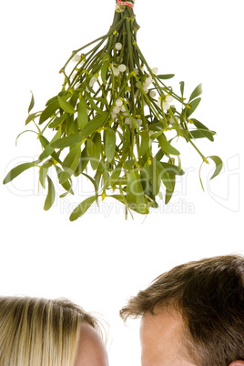 Couple standing beneath mistletoe