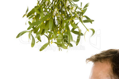 Man waiting under bunch of mistletoe