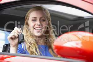 Junge Frau hält freudig den Autoschlüssel