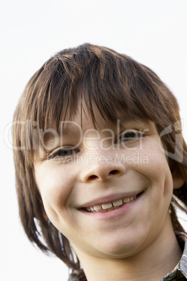 Junge mit längeren braunen Haaren lacht