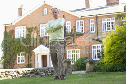 Ein Mann steht vor einer großen Villa