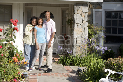 Eine Familie steht am Eingang ihres Hauses