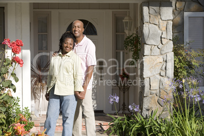 Ein Ehepaar steht auf der Terasse ihres Hauses