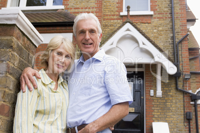 Ein Ehepaar steht vor einem Haus