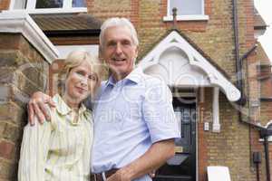 Ein Ehepaar steht vor einem Haus