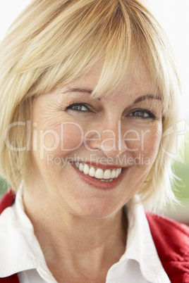 Ältere schöne Frau mit kurzen blonden Haaren strahlt in die Kamera