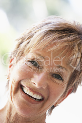 Ältere schöne Frau mit kurzen Haaren strahlt
