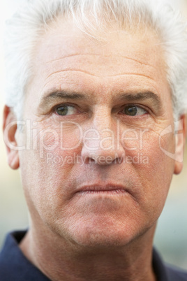Älterer Mann mit grauen Haaren blickt nachdenklich