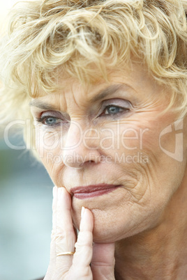 Schöne blonde Frau mittleren Alters blickt nachdenklich