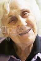 Alte Frau mit grauen Haaren lächelt zufrieden