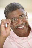 Älterer afroamerikanischer Mann mit Brille lacht in die Kamera