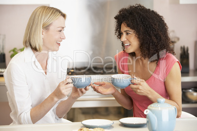 Female Friends Enjoying Tea And Cookies At Home