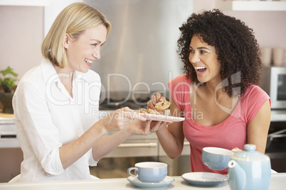 Female Friends Enjoying Tea And Cookies At Home