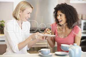 Female Friends Enjoying Tea And Cookies At Home