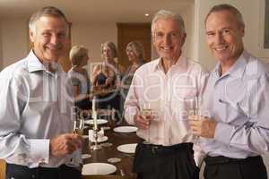 Friends Enjoying A Glass Of Champagne At A Dinner Party