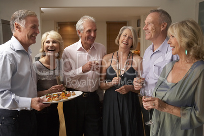 Man Serving Hors D'oeuvres To His Guests At A Dinner Party