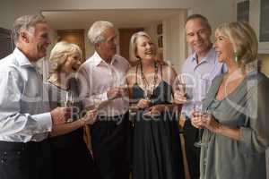 Friends Enjoying A Glass Of Champagne At A Dinner Party