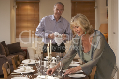 Couple Preparing Table For A Dinner Party