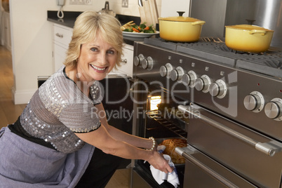Woman Taking Food Out Of The Oven