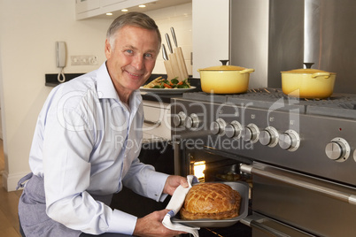 Man Taking Food Out Of The Oven