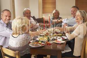 Friends Pulling Christmas Crackers At A Dinner Party