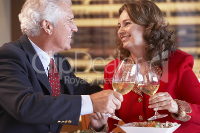 Couple Eating Dinner And Toasting With A Glass Of Wine