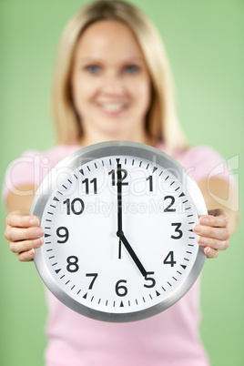 Woman Holding Clock Showing 5 O'Clock