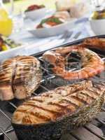 Salmon And Prawns Cooking On A Grill