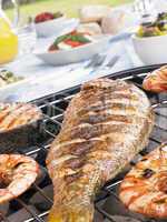 Fish And Prawns Cooking On A Grill
