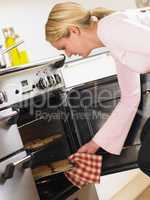 Woman Taking Cookies Out Of Oven