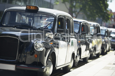 London Taxis Lined Up On Sidewalk