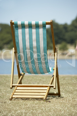 Lone Beach Chair Sitting Next To Water