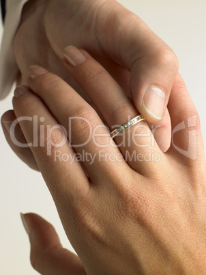 Man Putting Diamond Ring On Woman's Finger