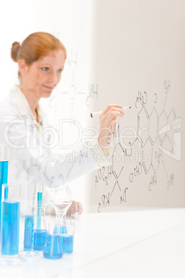 Woman scientist in laboratory write chemical formula