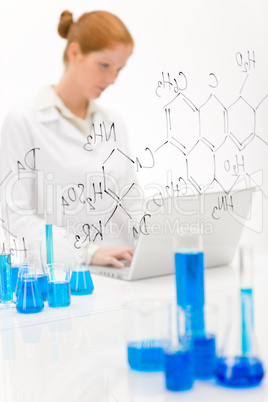 Woman scientist in laboratory with laptop