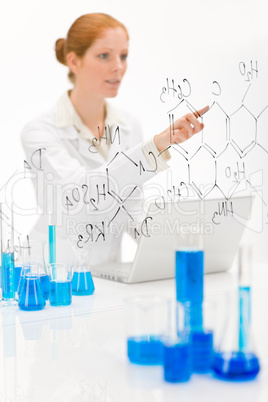 Woman scientist in laboratory with laptop