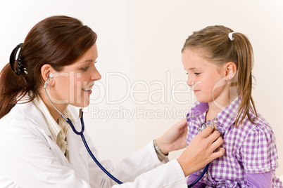 Female doctor examining child with stethoscope