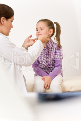 Female doctor examining child with sore throat