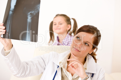 Young female doctor show x-ray to child