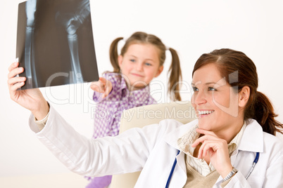 Young female doctor show x-ray to child