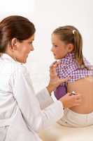 Female doctor examining child with stethoscope