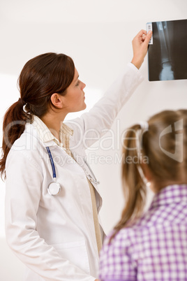 Young female doctor show x-ray to child
