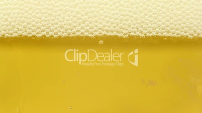Golden cold beer being poured into glass, close-up