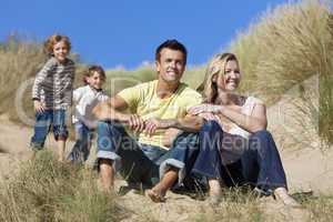Family Sitting on Beach Having Fun
