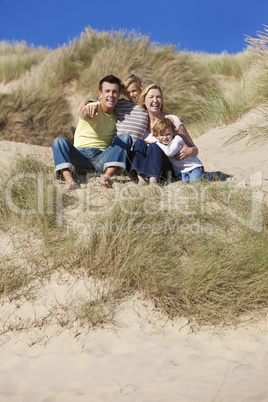 Mother, Father and Two Boys Sitting Having Fun At Beach