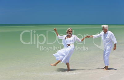 Happy Senior Couple Dancing Holding Hands on A Tropical Beach