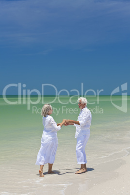 Happy Senior Couple Dancing Holding Hands on A Tropical Beach