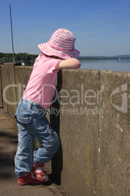 kleines Mädchen schaut auf den see